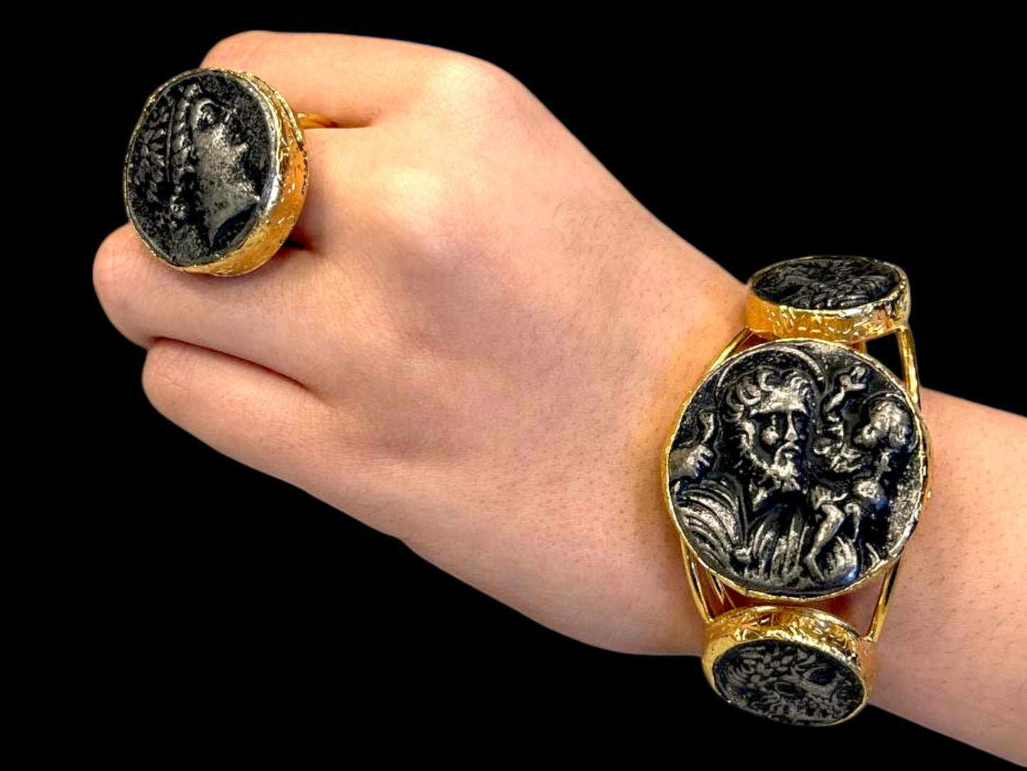a woman's hand wearing a gold and black bracelet