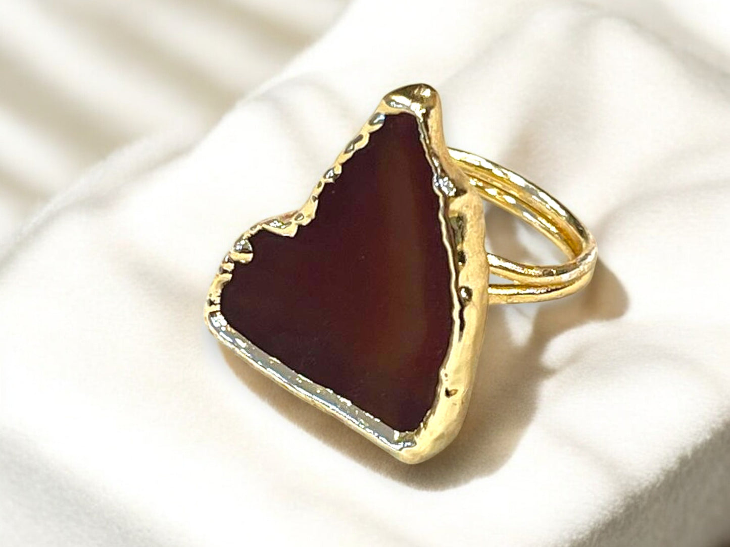 a gold ring with a red stone in it