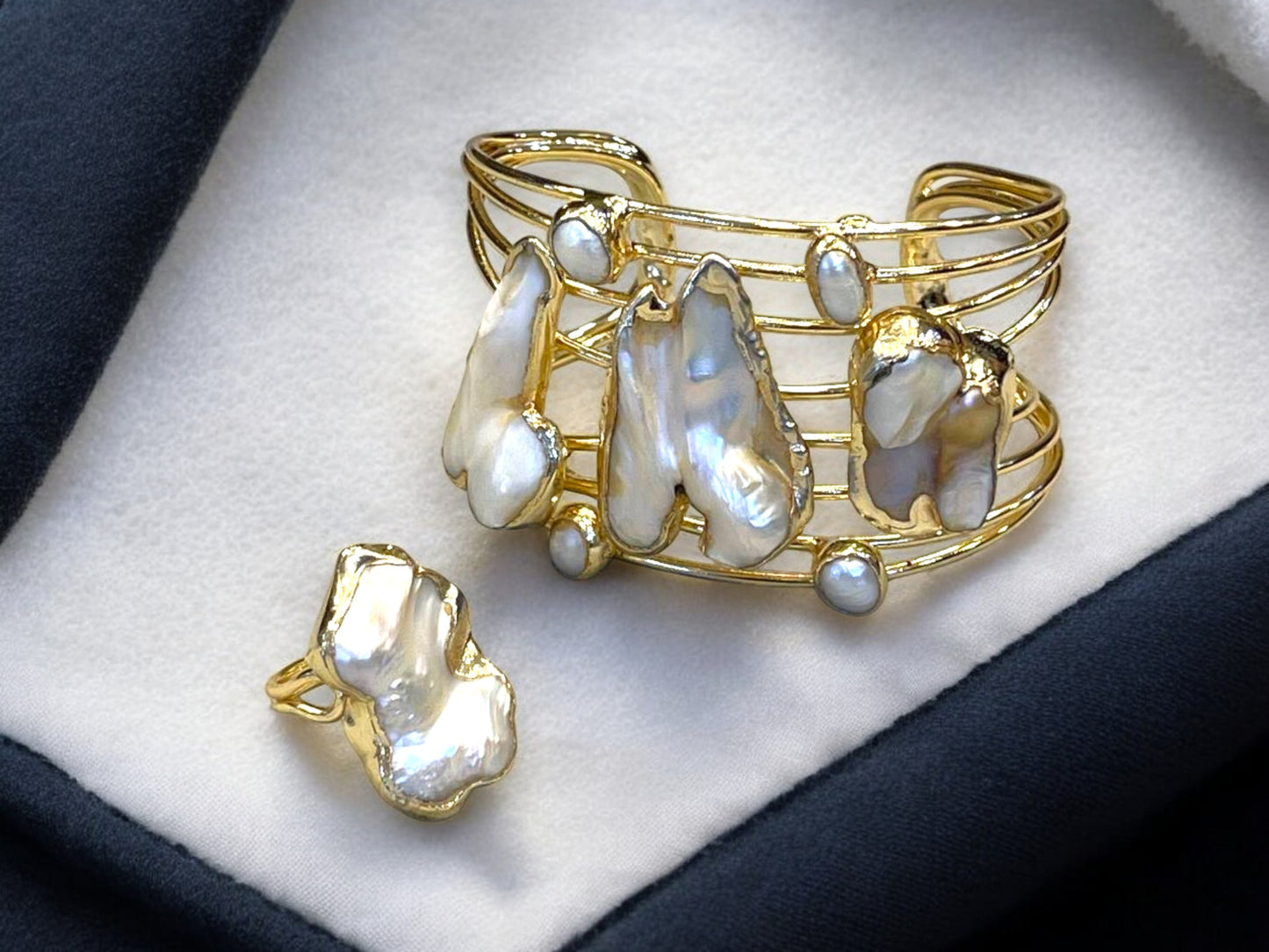a close up of a brooch with pearls on it