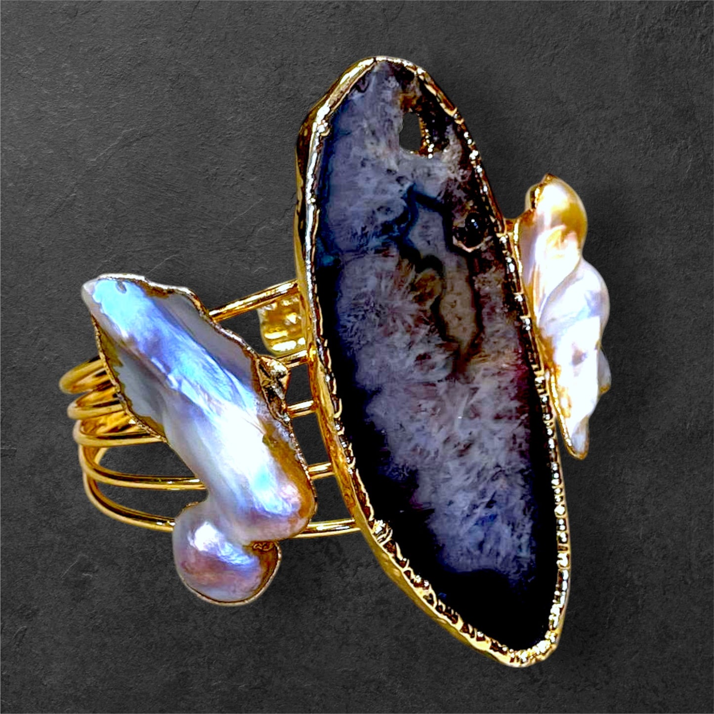 a gold ring with a large blue agate stone