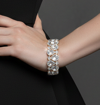 Diamond-studded bracelet on a woman's wrist against a black dress.