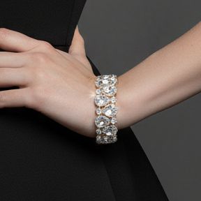 Diamond-studded bracelet on a woman's wrist against a black dress.