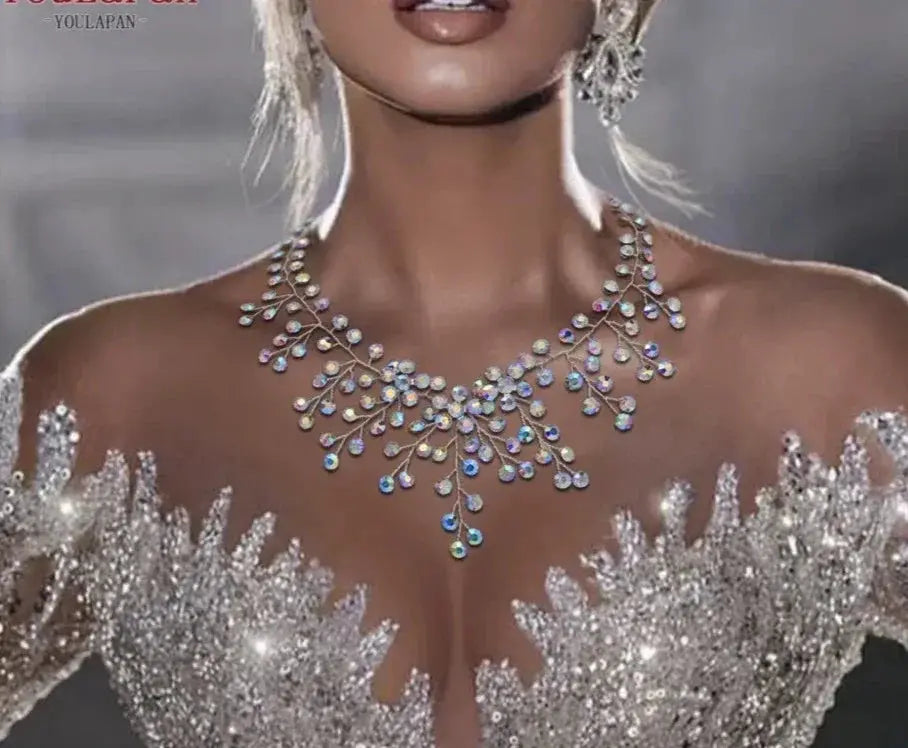 Iridescent crystal necklace with a water-drop pendant in a cascading modern choker design worn with a sparkling gown.